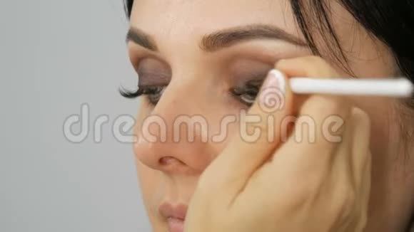 眼妆用专用画笔和灰色眼影蓝色的特写眼睛睫毛很长视频的预览图