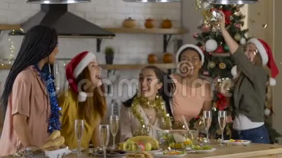 五个女朋友庆祝新年圣诞节扔纸屑大房子里舒适的餐厅慢动作视频的预览图