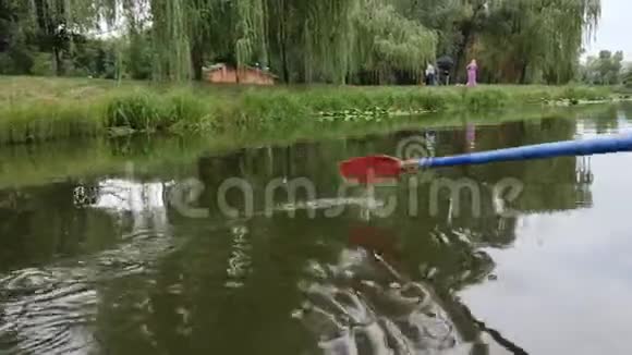 泡在水里在公园里用湖和睡莲把塑料桨合起来蓝色塑料桨瓦视频的预览图