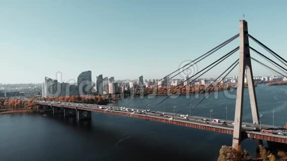市中心跨河的混凝土桥桥上繁忙的汽车交通空中无人机视野连接两个银行的桥梁视频的预览图