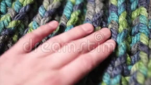 女性手摸着一堆五颜六色的羊毛软帽子或温暖的毛衣视频的预览图