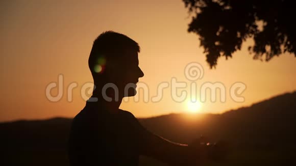 一个男人触摸和检查智能手表在美丽的日落背景的剪影视频的预览图