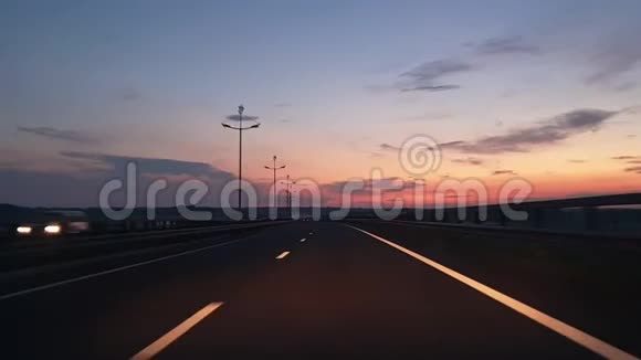 日出时在高速公路上开车通过前窗车查看POV公路旅行概念视频的预览图