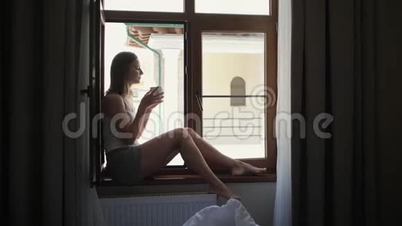 女人坐在窗台上喝咖啡视频的预览图