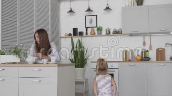 早上和一个孩子在家妈妈坐在厨房喝咖啡视频的预览图