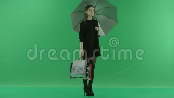 漂亮的年轻女人买完包后躲在伞下颜色是绿色的钥匙视频的预览图