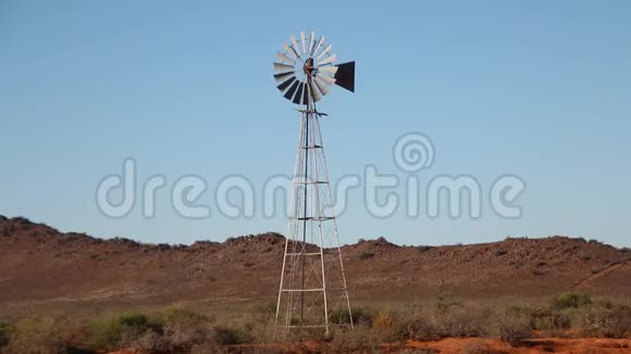 在温暖的阳光日风车或风泵在田野里视频的预览图