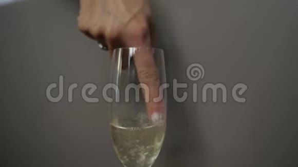 那个女人用手指在杯子里搅动起泡酒视频的预览图