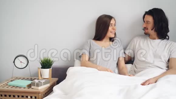 怀孕女孩送丈夫礼物盒与怀孕测试接吻拥抱床视频的预览图