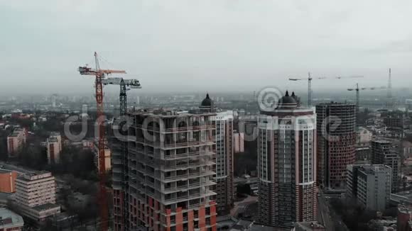 一群戴着橙色头盔的白种人工人在未完工建筑的屋顶上工作高层建筑工人视频的预览图