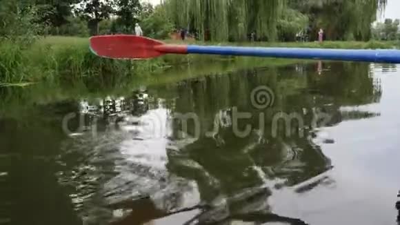 在水面上划桨城市公园的湖面上升起了红色和蓝色的桨水滴流下来视频的预览图