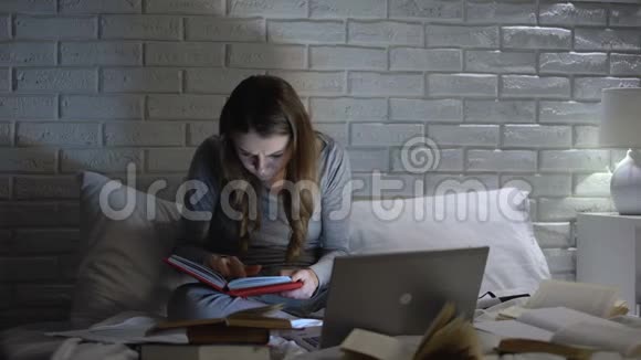 女学生看书深夜用笔记本电脑打字截止日期视频的预览图