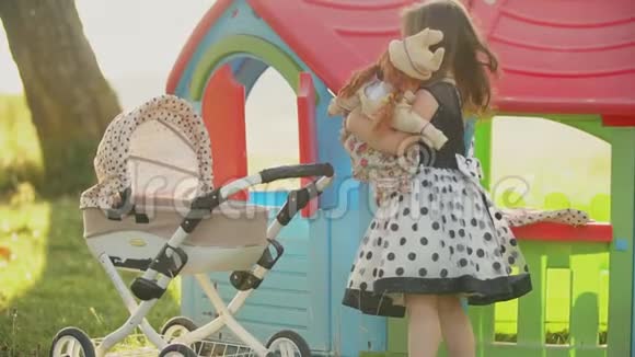 小女孩在玩具车附近玩娃娃视频的预览图