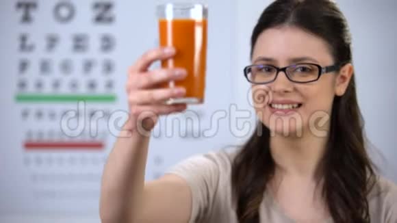 戴眼镜的女人用胡萝卜汁胡萝卜素维生素视频的预览图