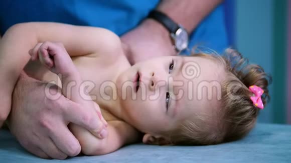 医疗中心一位医生和一个患有脑瘫疾病的小婴儿一起做运动一个婴儿看着医生视频的预览图