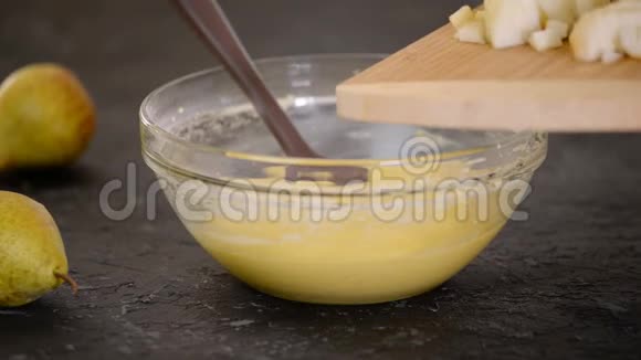 女人在面糊中加入切碎的梨制作美味梨饼的过程视频的预览图