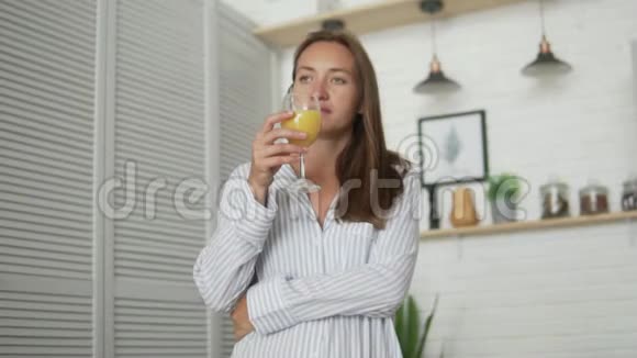 早上在厨房喝新鲜橙汁的女人视频的预览图