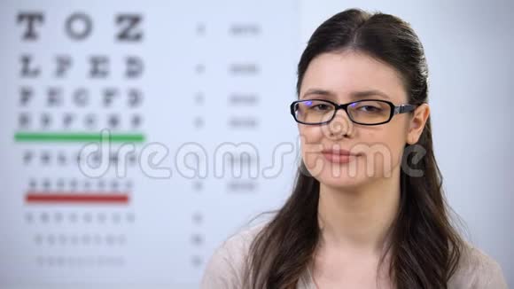 戴眼镜的微笑女人展示隐形眼镜盒推荐新技术视频的预览图