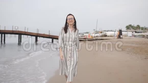 快乐的女人光着脚在海滩上玩穿着一件长裙子视频的预览图