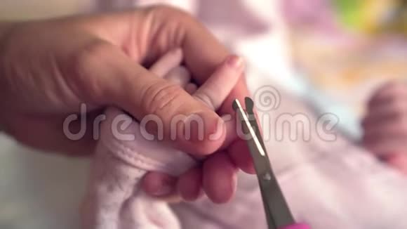 女人剪了婴儿的指甲女人在家给孩子剪指甲母亲和孩子卫生观念手特写视频的预览图