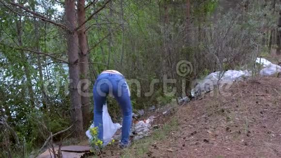 志愿者在公园湖边的森林里捡垃圾收集垃圾视频的预览图