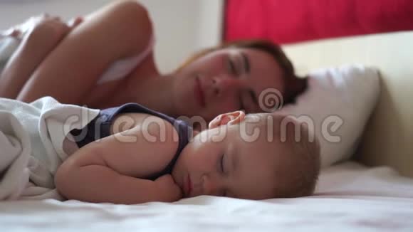 白天妈妈和宝宝在一张大床上缓慢地睡得香甜视频的预览图