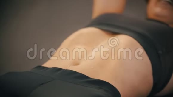 一位在健身房训练的女运动员她的腹肌肌肉腹部的汗水视频的预览图