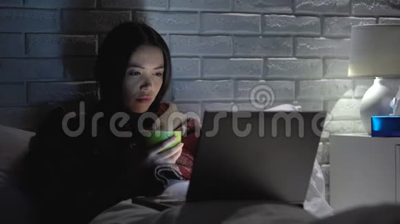 患病妇女患流感发烧喝茶看电影回家治疗视频的预览图
