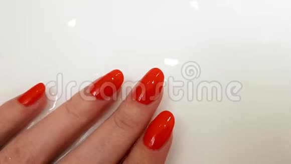 红色指甲经典美甲女性手在白色表面与水水疗日视频的预览图