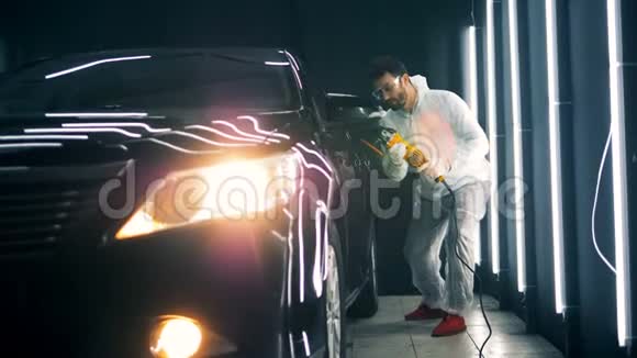一个男技师正在给一辆黑色汽车的门加油视频的预览图