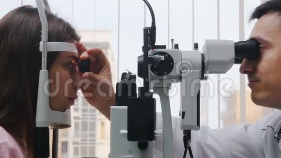 眼科治疗一名年轻女子用机器检查她的视力瞳孔对光线投掷的反应视频的预览图