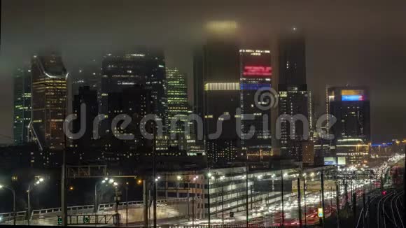 摩天大楼市中心的夜景和隐藏建筑物顶部的雾中的交通时间流逝视频的预览图