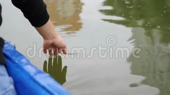 女人的手轻轻地抚摸着湖面上的绿水快乐的女孩慢慢地牵着她的手在水上靠近女人的手视频的预览图