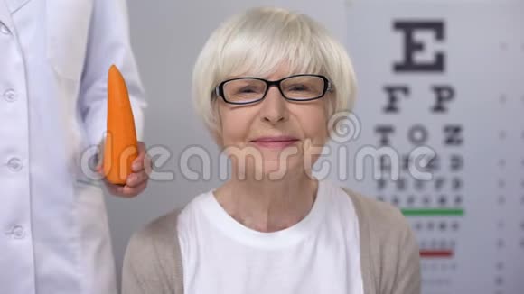 Oculist向微笑的老太太提出胡萝卜天然的视觉维生素视频的预览图