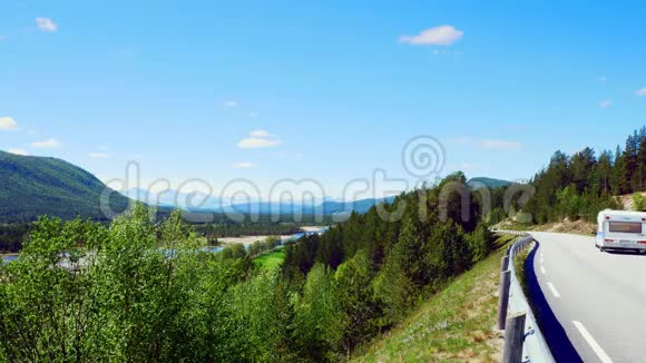 郁郁葱葱的山谷夏季景观一条河流从远处白雪覆盖的山脉流动一辆汽车拉着露营者视频的预览图
