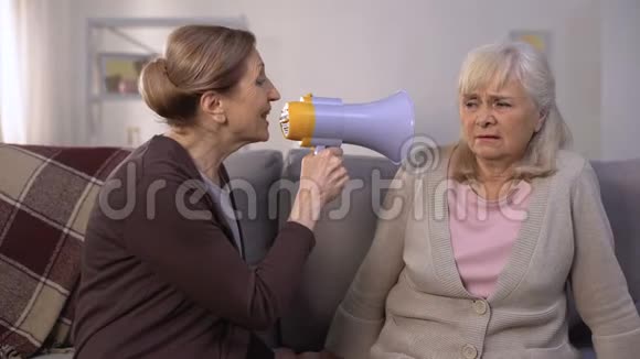 成熟的女人用扩音器对失聪的老妇人说话听问题笑话视频的预览图