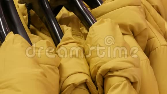 暖黄色的冬衣挂在女式服装精品店衣架上视频的预览图