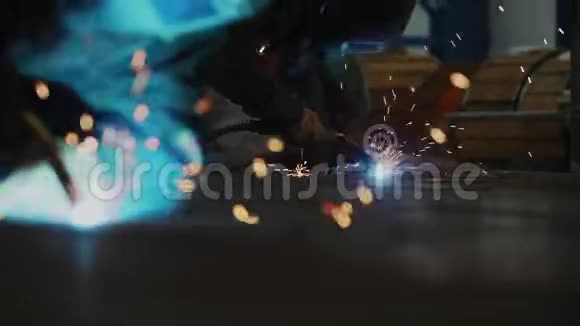 戴口罩的工人在车间特写的地板上焊接细节视频的预览图