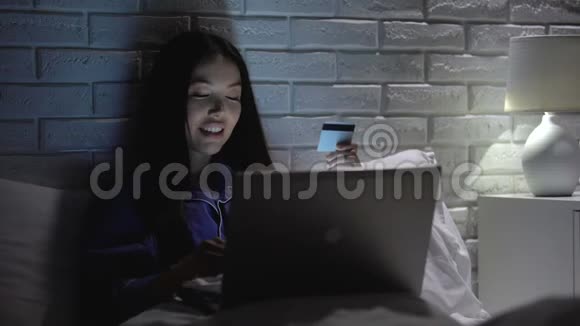 快乐的亚洲女孩进入信用卡数据晚上购物黑色星期五视频的预览图