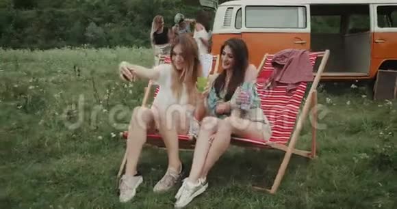 美丽的女士们在野餐时坐在野餐椅上自拍背景的朋友们花了一组时间视频的预览图