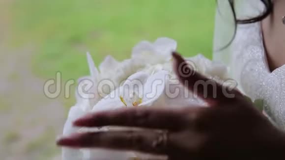 新娘捧着花束滴在一束白玫瑰上视频的预览图