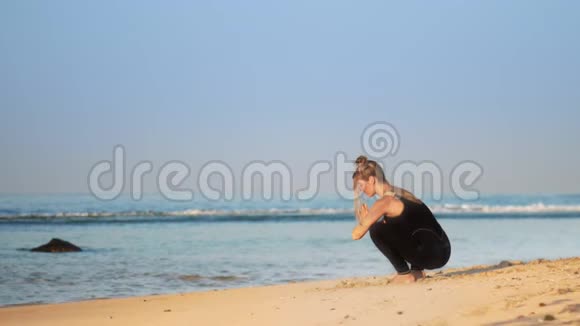 太空包子练习瑜伽的女孩在沙滩上摆姿势视频的预览图