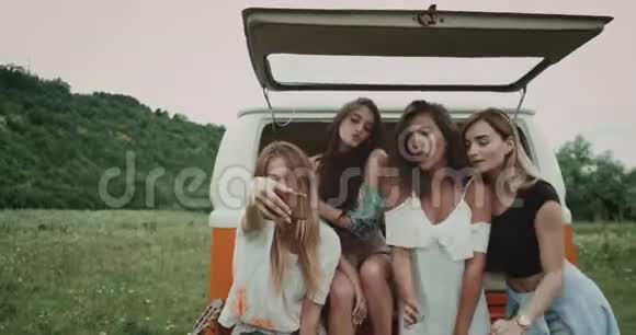 快乐的微笑年轻的女士们在一起很愉快带着自拍坐在中间的复古的背面视频的预览图