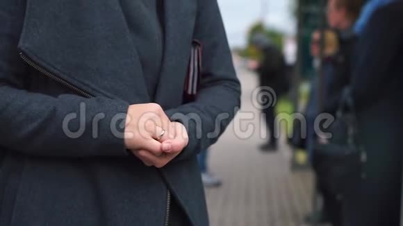 手放在肚子上在公共汽车站排队等候视频的预览图