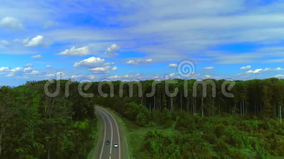 空中无人机视野汽车正沿着高速公路行驶在山区茂密的森林中间4克视频的预览图