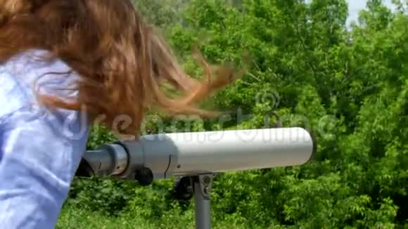 布鲁内特在公园里看城市观测望远镜视频的预览图