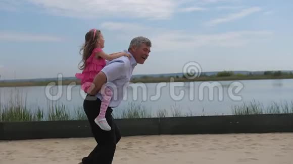 从长远来看和祖父在海滩上玩耍的女孩祖父骑孙女4K慢慢视频的预览图