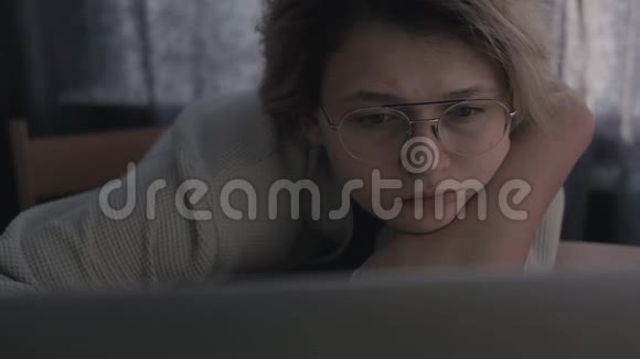 戴眼镜的沮丧女人坐在房间的电脑后面视频的预览图