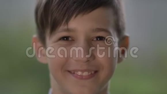 一个有趣的男孩在户外笑的肖像合上视频的预览图