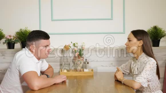 担心的男人用手指敲桌子严肃的女人在咖啡馆里视频的预览图